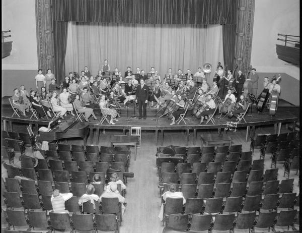 Elevated view of the Central High School orchestra on stage, with a few observers.