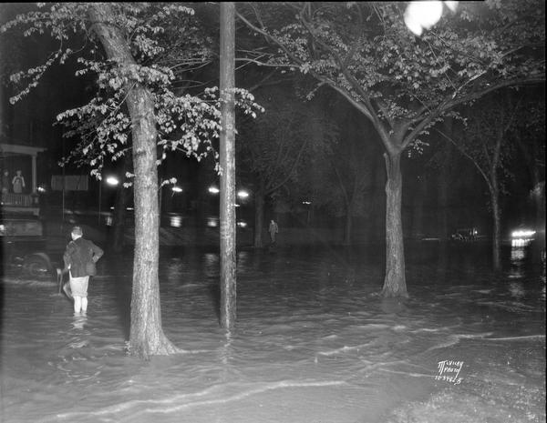 View of Langdon Street during flood from rain. A man is standing ankle deep in water.