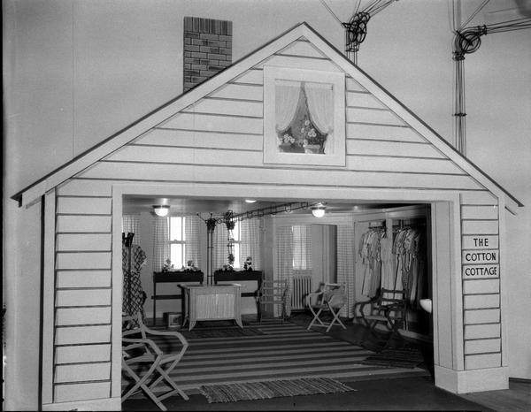 Kessenich's "Cotton Cottage" (built to look like a cottage with yellow woodwork, red checked gingham curtains and rag rugs on the floor) built on the second floor at the entrance to their summer cotton dress department.