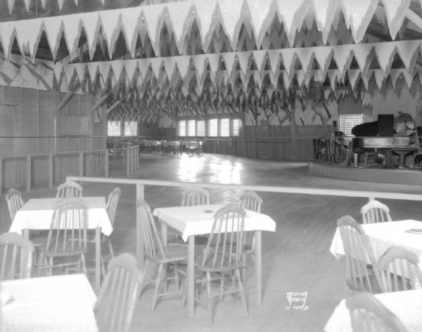 Interior of Ambassador Club at Bernard's Park beyond Maple Bluff on Lake Mendota, dining and dancing, boat rides and picnicking featured. Music nightly by Dexters Pennsylvanians on raised stage with grand piano.