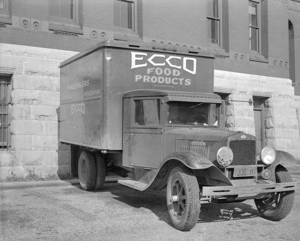 Front view International delivery truck. "Ecco Food Products"  "Marshfield Grocer Co. Inc. Wholesalers Marshfield Wisconsin." Taken next to Dane County Courthouse? This truck was driven by Frank McCorison, accused of first degree murder, and Harvey McCorison, charged with assault, in the death of Gunder Felland, a Dane county farmer participating in the milk strike.