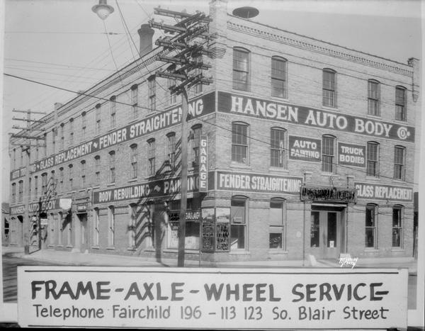 Advertisement using 4248B-1. Hansen Auto Body Co. Bldg, 113 - 123 S Blair Street. Signs painted on the building: "Auto trimming glass replacement" Torgeson Bros General Auto repairing "Fender Straightening" with advertising banner "Frame-Axle-Wheel Service" on the negative.