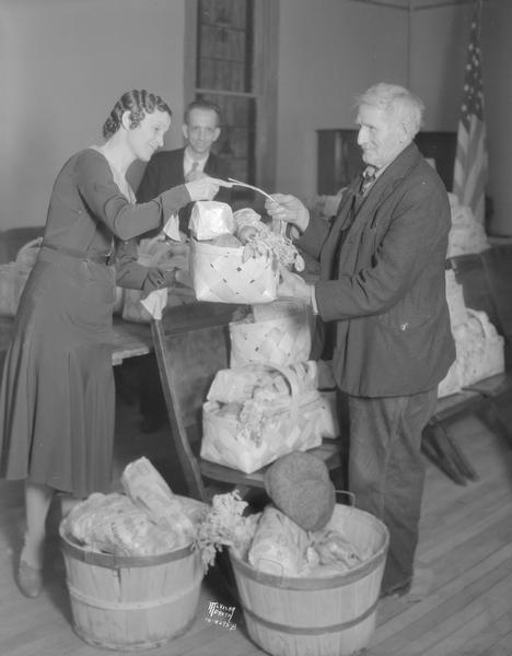 Volunteers of America volunteer handing out a Thanksgiving food basket.