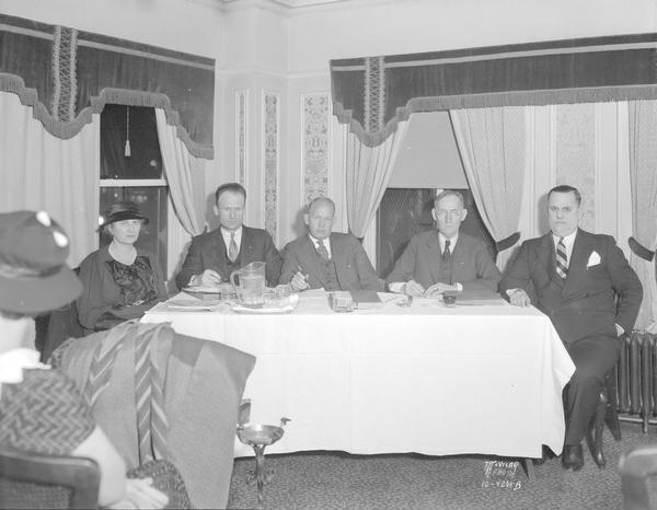 National Recovery Act compliance board members, l-r: Mrs. George J. Ritter, Jerome B. White, Ray M. Stroud, George P. Hambrecht, and Roy R. Feeney sitting around a table at the Loraine Hotel.