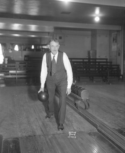 66 year old George Oakey, bowler at Madison Alleys, 110 N. Fairchild Street, ready to throw his ball. He scored a perfect 300 game, a total of 1,406 in six games, and a city and state season's record of 737 in another three-game series all between Tuesday noon and Wednesday midnight.