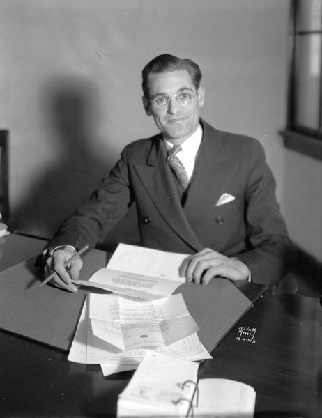 Portrait of Mr. Edwin Schneiders sitting at a desk.