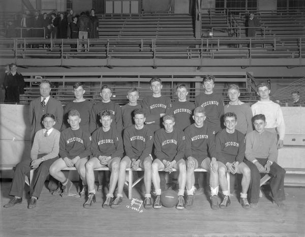 Wisconsin High School basketball team. Twelve players are in uniform, with five other men.