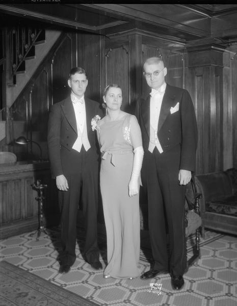 Mr. & Mrs. Erwin Schmidt and Dr. Kenneth Kemmer in formal dress at the Attic Angel Ball in the Loraine Hotel.