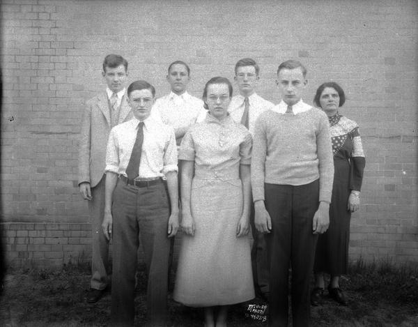 Group portrait of six members of the Wisconsin High School debating teams, and their teacher (unnamed). The students are, left to right front row: Farrington Daniels, Pauline Coles, and Carlton Breckler of the affirmative team. Back row left to right: William Collins,  Fred Butler, Laird McNeel of the negative team.