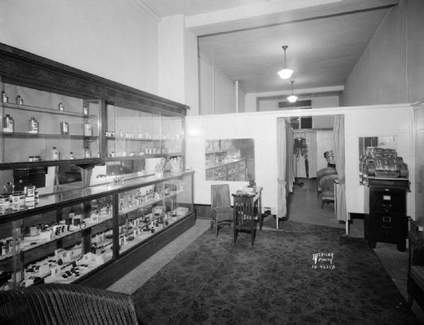 Interior of Luzier Beauty Shop, in the Gay Building, 16 North Carroll Street, showing the cash register, displays of products, manicure table, and a view through a door into a room with driers.
