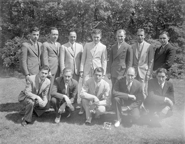 Group portrait of twelve men who are members of the Hills Department Store orchestra.