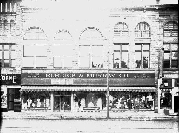 Burdick and Murray Department Store, 15-17-19 E. Main Street. Signs in the windows read: "July Clearance Sale."