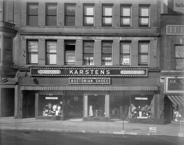 F.W. Karsten's men and boys clothing store, 22-24 N. Carroll Street, with "Bostonian Shoes" sign. Signs in upper story windows read: "Harvey Dentists" and "Colt School of Art."