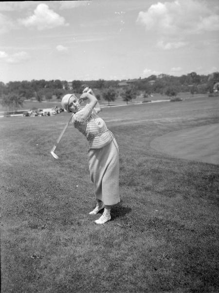 Mrs. Karl Luetke, Green Lake, Wisconsin, swinging a golf club, finalist for Women's State Golf Championship.