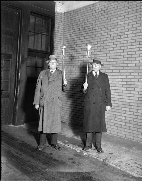 Otto Burmeister, Middleton, and E.J. Onstad, Madison, carrying kerosene torches which will be used in a Progressive party torchlight parade that evening.