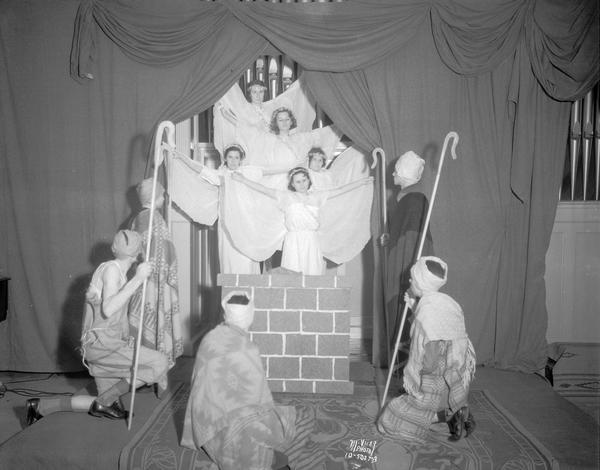 First Christian Church school students and choir members dressed as angels and shepherds in a scene from a Christmas pageant "The Promised One" in Esther Vilas hall at the YWCA.