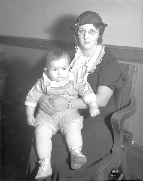 Woman sitting in a chair, holding a baby. Taken for Sheboygan Press Newspaper.