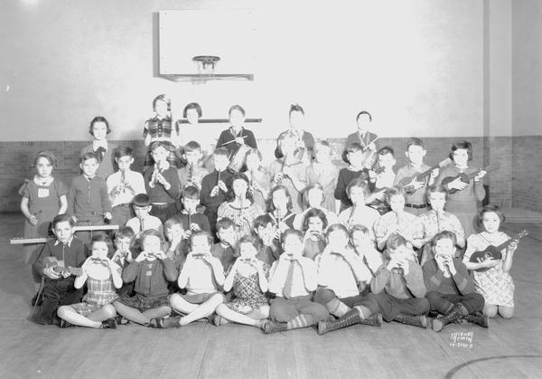 Group portrait of Emerson School orchestra members with small instruments.