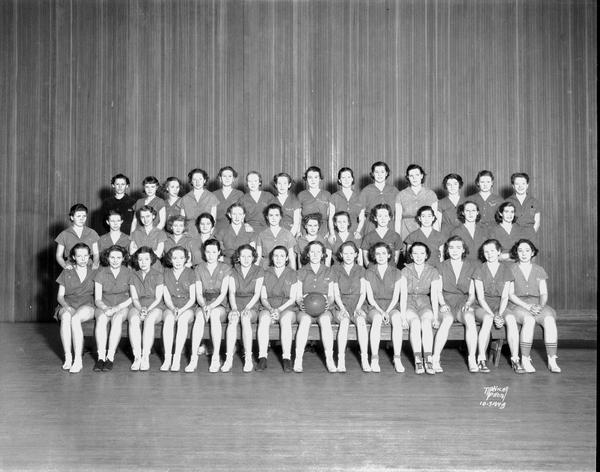 Group portrait of East High School girls basketball team in uniform.