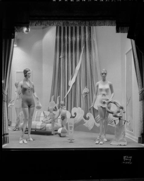 Harry S. Manchester Inc. display window of B.V.D. swimsuits for children and women. One of the mannequins has an inflatable water toy.
