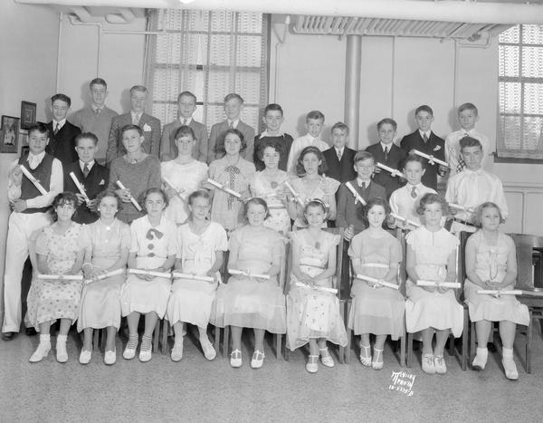 Group portrait of eighth grade class at Franklin School, 305 W. Lakeside Street. The students are holding their diplomas.
