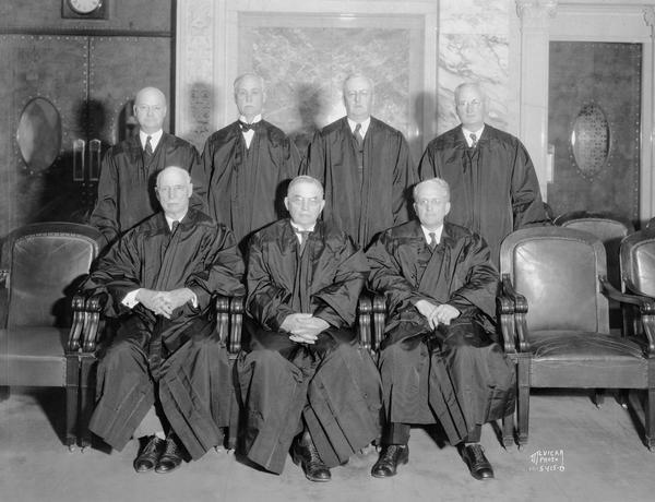 Group portrait of Wisconsin Supreme Court Justices in their robes taken in a room at the Wisconsin State Capitol. Chief Justice Marvin B. Rosenberry, Justices Chester A. Fowler, Oscar M. Fritz, George B. Nelson and Joseph Martin.