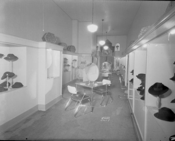 Nancee Hat Shop, 7 S. Pinckney Street, interior view with hat displays, tables with mirrors and chairs for customers.