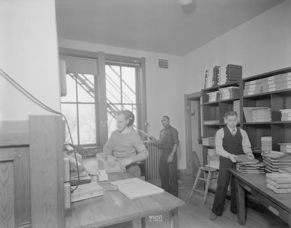 Three employees in the CUNA (Credit Union National Association) shipping room, 142 East Gilman Street.