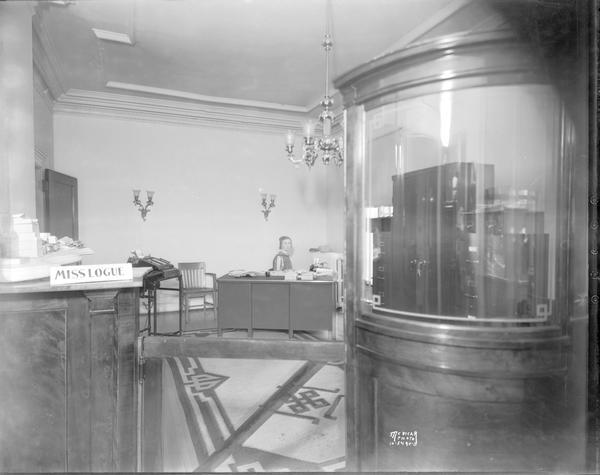 Helen Logue's office with female employee (bookkeeper) sitting behind a desk at CUNA (Credit Union National Association), 142 East Gilman Street.