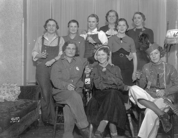 Group portrait of nine women dressed in costumes and holding drink glasses. Taken for Dorothea Lay at 141 S. Butler Street.