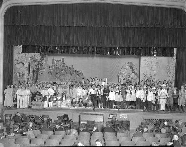 Group portrait of the East High School operetta "Prince of Peddlers" cast on stage.