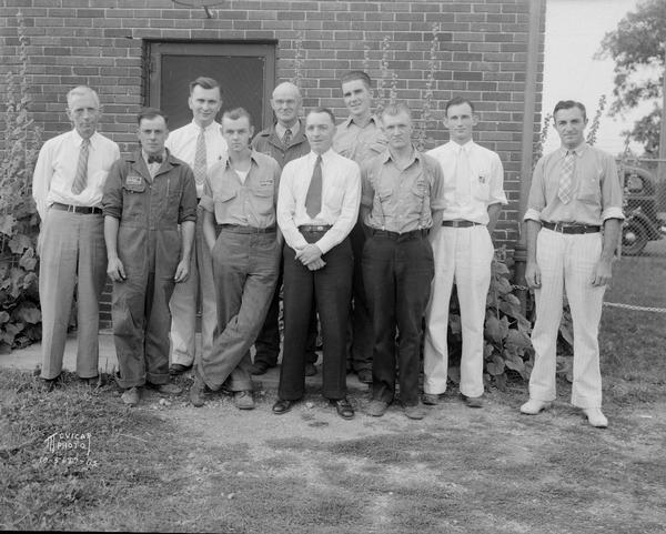 Outdoor group portrait of ten male employees of the Philgas Co.
