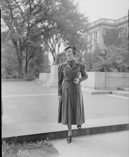 Woman model wearing green dress posing near the Lincoln statue on Bascom Hill. For: Kessenich's.