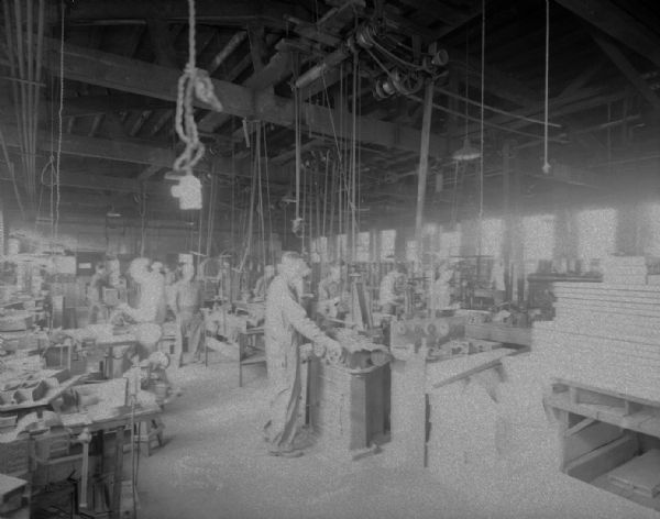 Interior view of men working inside Rushour Manufacturing Company at 2070 Helena Street.