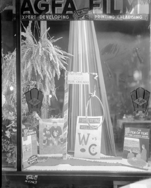 Homecoming display window at McVicar Photo Service, 751 University Avenue, featuring Wisconsin vs. Chicago football game with advertising for Agfa film. Also shows a noose with sign that reads: "Another Loop for Chicago."