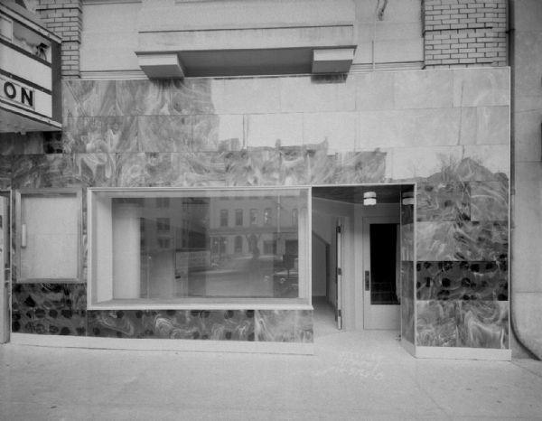 Savidusky's Cleaners and Dyers, at new location at 115 Monona Avenue. (Martin Luther King Jr, Boulevard) next to Madison Theatre. Sign reads: "Ladies plain coat 90 cents," "Suede-Leather jackets given our Nulife process will retain their original soft suede finish."