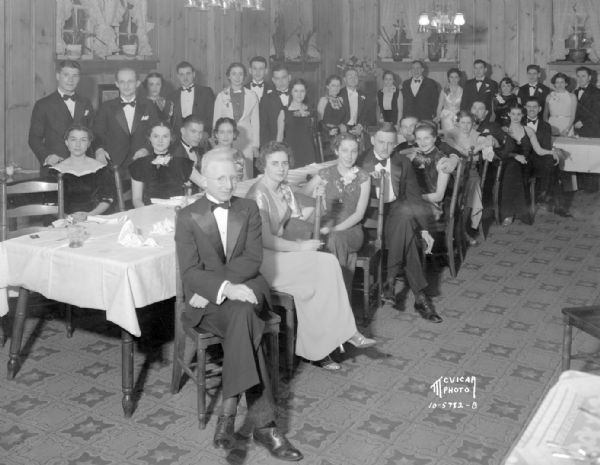 Group portrait of men and women in formal dress at a dinner party at Kennedy Manor, 1 Langdon Street.