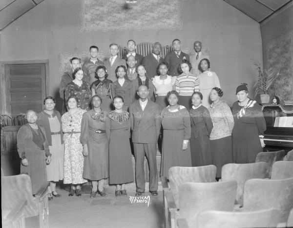 Group portrait of African American choirs from Mount Zion Baptist Church and St. Paul's A.M.E. Church, taken at Mount Zion, 548 W. Johnson Street. (?) Top row l to r: Merle Newville, Walter Blair, Charles Newville, David Sims, Jesse Guy, Charles Givens, Sam Sims; 2nd row l to r: Rose Newville, Eddie Mae Champion, Dorothy Anderson, Hermon Jordon, Rosemary Sanders, Dorothy Newville, Ola Jordan; botton row l to r: Anna Hines, Elizabeth Mitchell, Margaret Russell, Mamie Mathews, Mary Sanders, Rev. P.L. Sanders, Ida Smith, Blossom Champion, Mary Wiley and Margaret Skenandore.