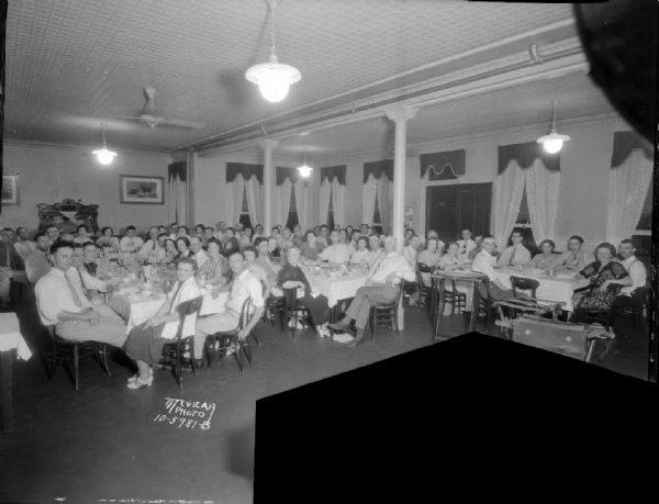 Group portrait of members sitting at tables for Madison Turnverein (Turners) banquet at Simon Hotel.