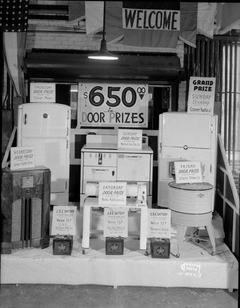 Display of daily door prizes, at East Side Business Men's Association Fall Festival, "$650 in Door Prizes," showing household appliances, batteries and radio.