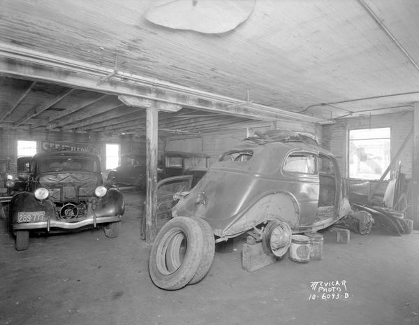 Interior, Middleton Garage showing several cars, one of which has its rear tires removed.
