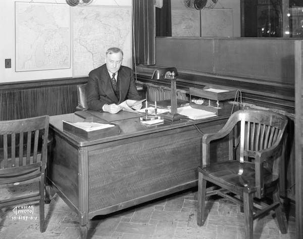 Earl W. Barnhardt sitting at a desk at Groves School for Secretaries, 502 State Street.