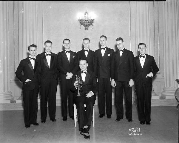 Group portrait of eight men in formal dress, the Art Fields orchestra. One man (Art Fields?) is holding a trumpet.