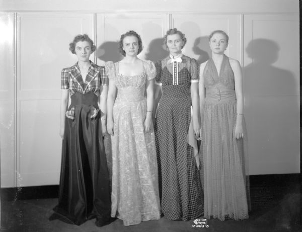 Four Madison Business College women modeling floor-length dresses for Kessenichs store.