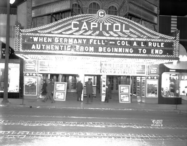 Capitol Theatre marquee at night showing "'When Germany Fell' with Col. A.L. Rule. Authentic from beginning to end." People are purchasing tickets at the ticket booth.