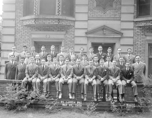 Group portrait of Pi Lambda Phi fraternity members in front of their house, 10 Langdon Street.