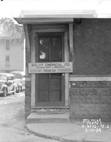 Solvit Chemical Co. sign nailed across two doors numbered 107 & 105, sign says: "Keep Out,  Badger 4717 — Madison, Wis., 'Poison Gas' Fumigation."