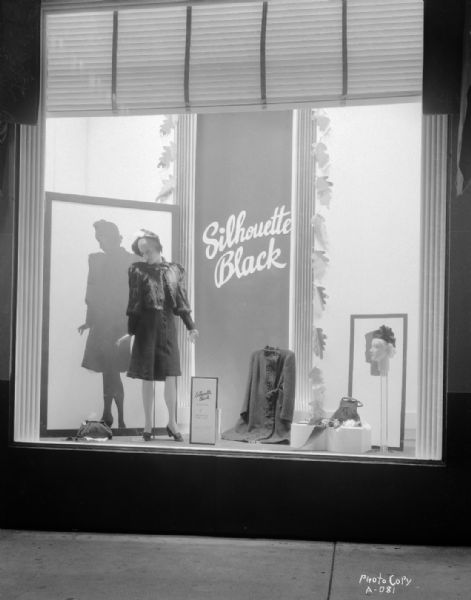 Manchester's, Inc., Department Store, 2-6 East Mifflin Street, "Silhouette Black" window display, with mannequin wearing a coat and hat, with other coats, hats and purses in the window.