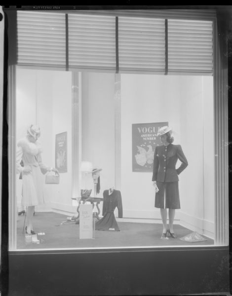 Manchester's, Inc., "Vogue Americana Number - USA Fashion" window showing two mannequins modeling women's dresswear.