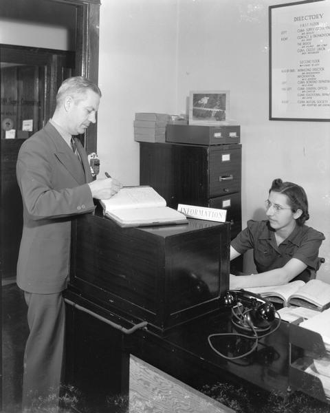 Man signing register at the CUNA (Credit Union National Association) information desk, 1342 East Washington Avenue.